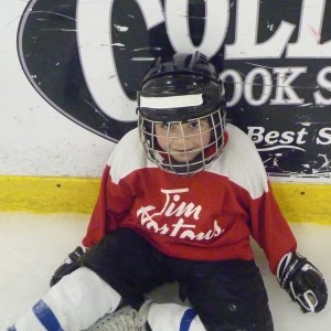 A player sits along the boards during warm ups for the Learn To Play Hockey Program at Bird Arena in Athens, Ohio. (Credit: Jacob Betzner, The Essay Magazine)